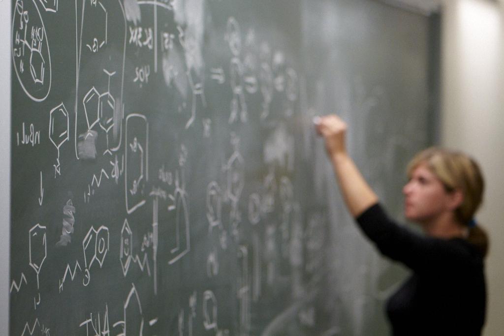 A student works on chemistry at the chalkboard.